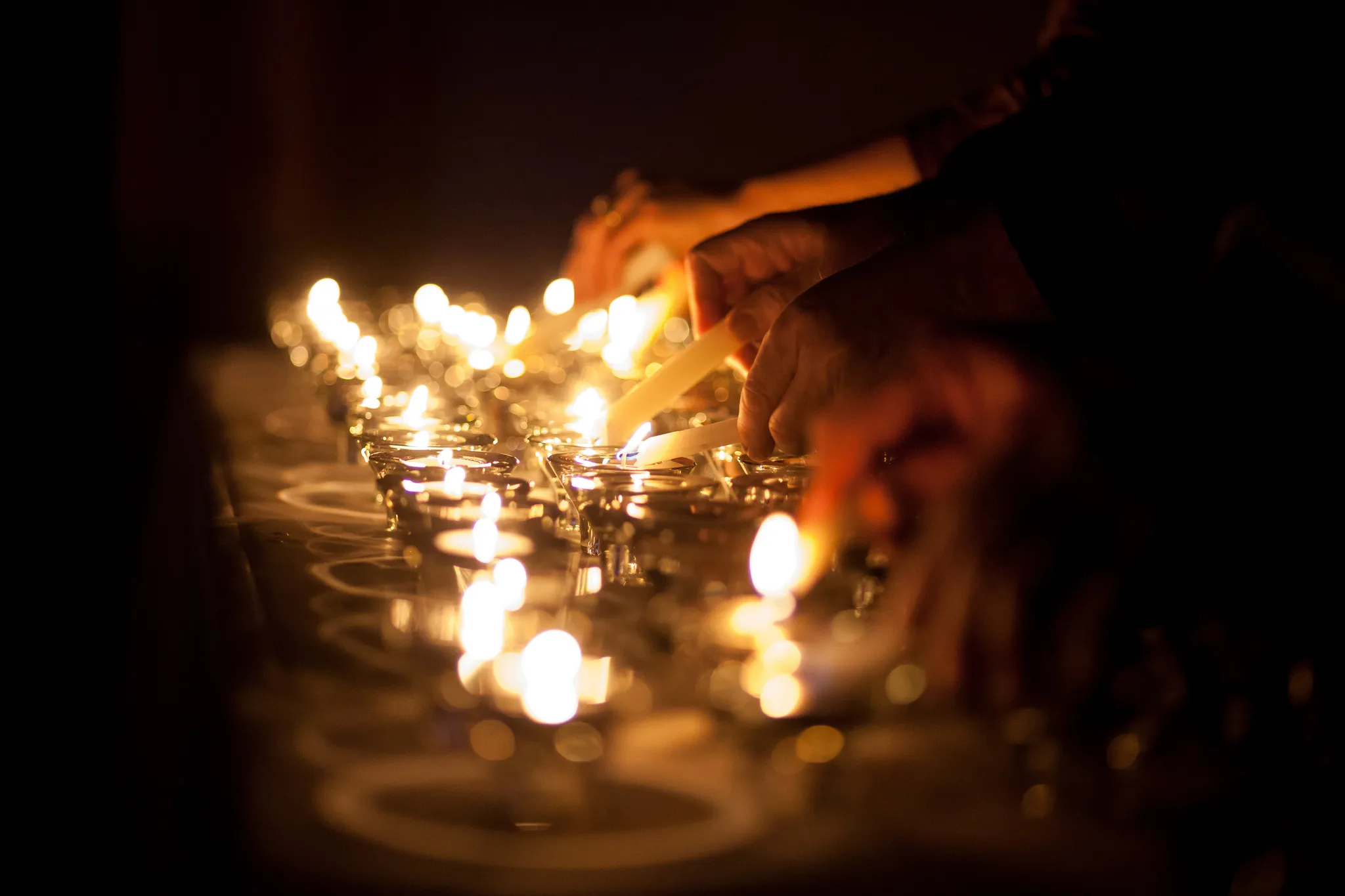 People lighting candles.